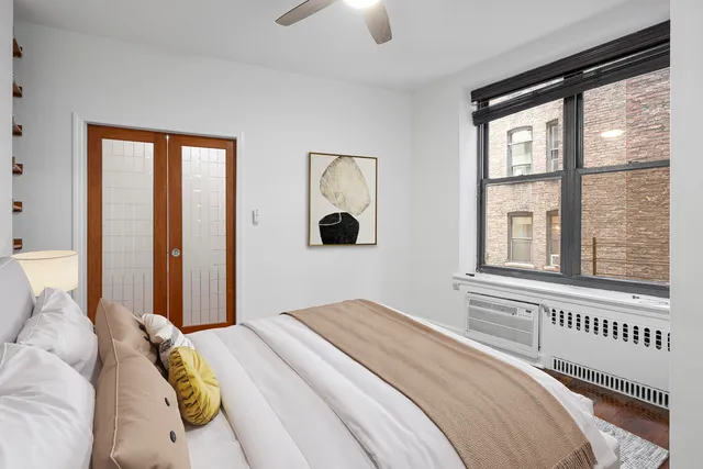 a bedroom with a bed and a large window