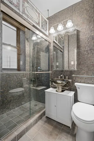 a bathroom with a sink a toilet and shower