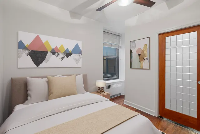 a bedroom with a bed and wooden floor