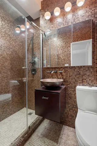 a bathroom with a sink a toilet and shower