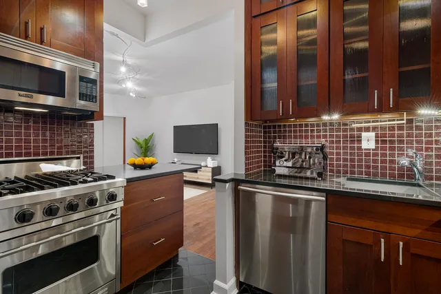 a kitchen with stainless steel appliances a stove a sink and a microwave