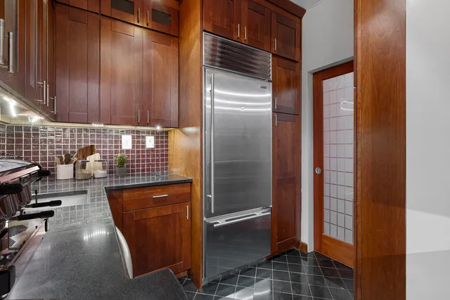a kitchen with refrigerator and cabinets