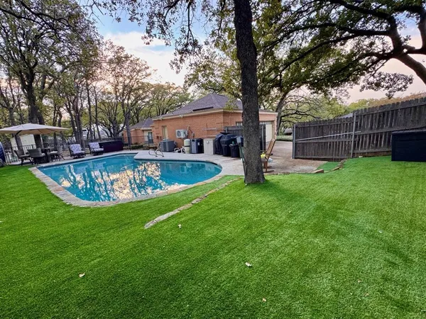 a view of a house with backyard and a tree