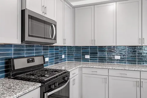 a kitchen with granite countertop a stove sink and cabinets