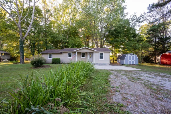a front view of a house with a yard and trees