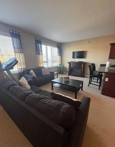 a living room with furniture a large window and a flat screen tv