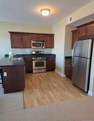 a kitchen with stainless steel appliances granite countertop a refrigerator stove and a sink