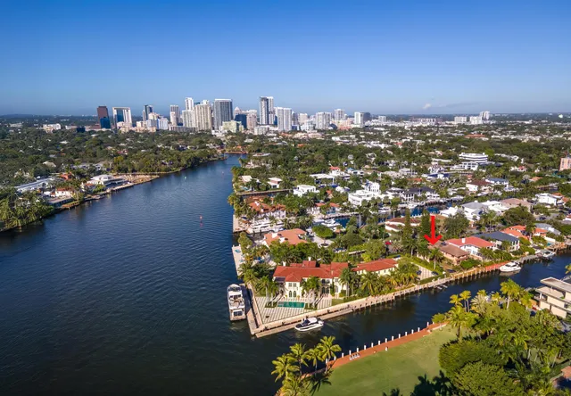 an aerial view of a city with lots of residential buildings ocean and mountain view in back