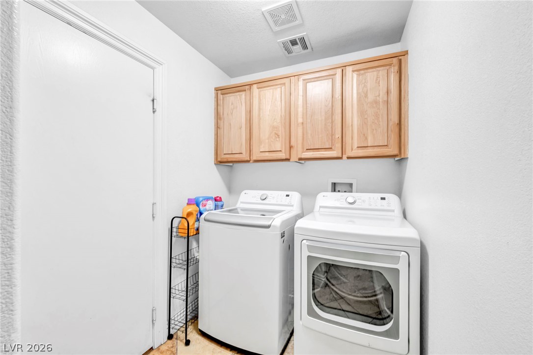 6405 North Raptor Court North Las Vegas, NV 89084 - Photo 40 of 66 Functional laundry room equipped with modern appliances and practical cabinetry for seamless home organization.