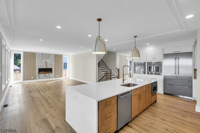 a large kitchen with kitchen island a stove a sink a center island and wooden floor