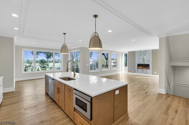 a kitchen with stainless steel appliances granite countertop a sink and a wooden floor