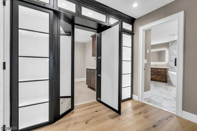 a view of a hallway with wooden floor and a living room