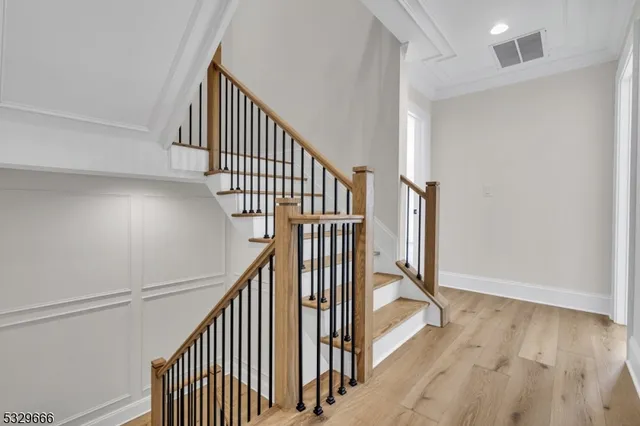 a view of staircase with wooden floor and white walls