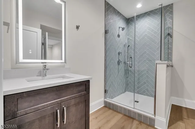 a bathroom with a shower sink vanity and mirror