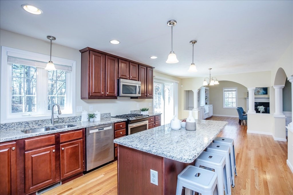 294 River Street Billerica, MA 01821 - Photo 13 of 42 a kitchen with stainless steel appliances granite countertop wooden cabinets a stove a sink and dishwasher a kitchen island with wooden floor