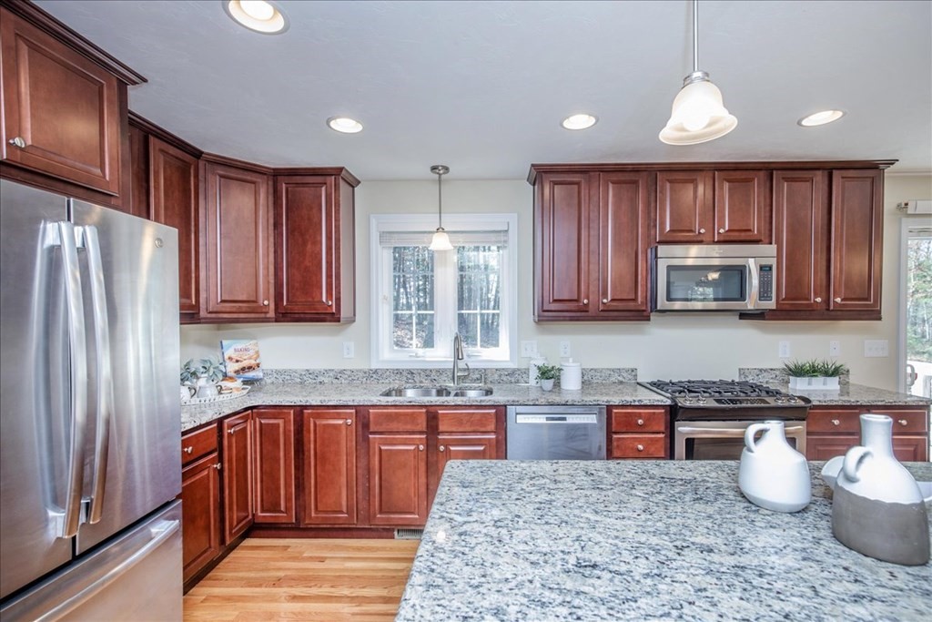 294 River Street Billerica, MA 01821 - Photo 14 of 42 a kitchen with wooden cabinets and stainless steel appliances