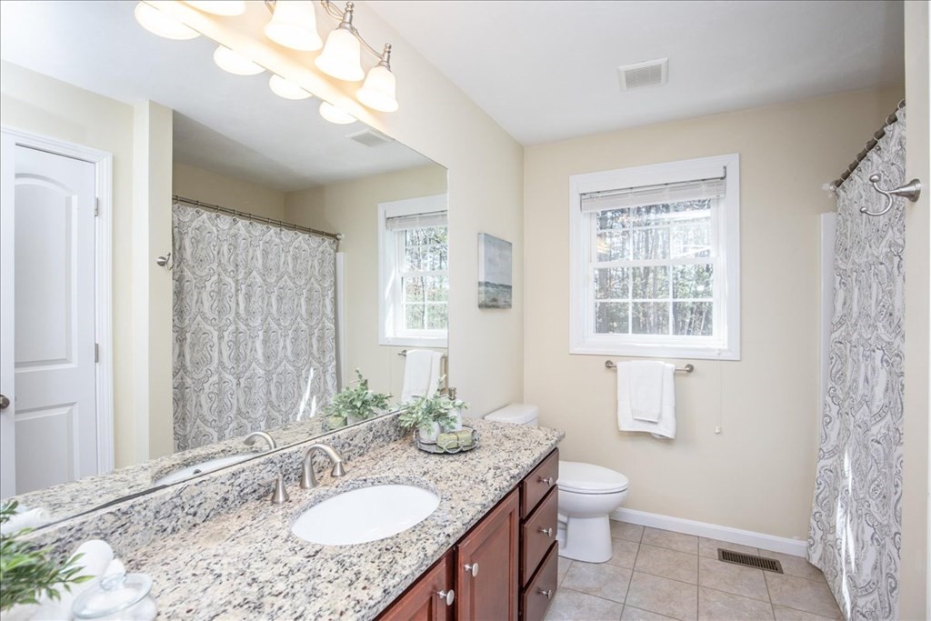 294 River Street Billerica, MA 01821 - Photo 31 of 42 a bathroom with a granite countertop sink a toilet and a mirror