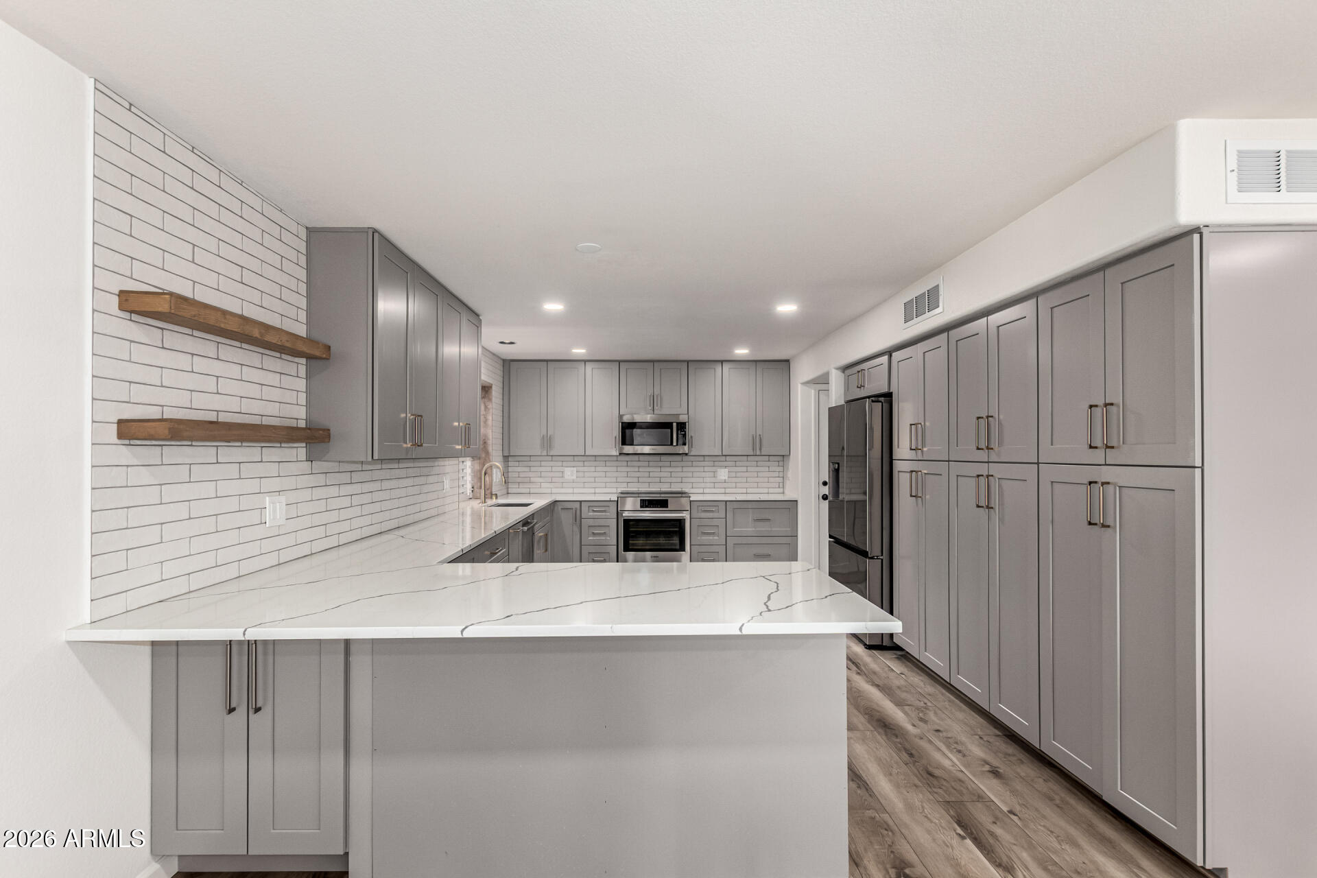 6455 East Raftriver Street Mesa, AZ 85215 - Photo 13 of 36 a kitchen with stainless steel appliances kitchen island granite countertop a refrigerator and a sink