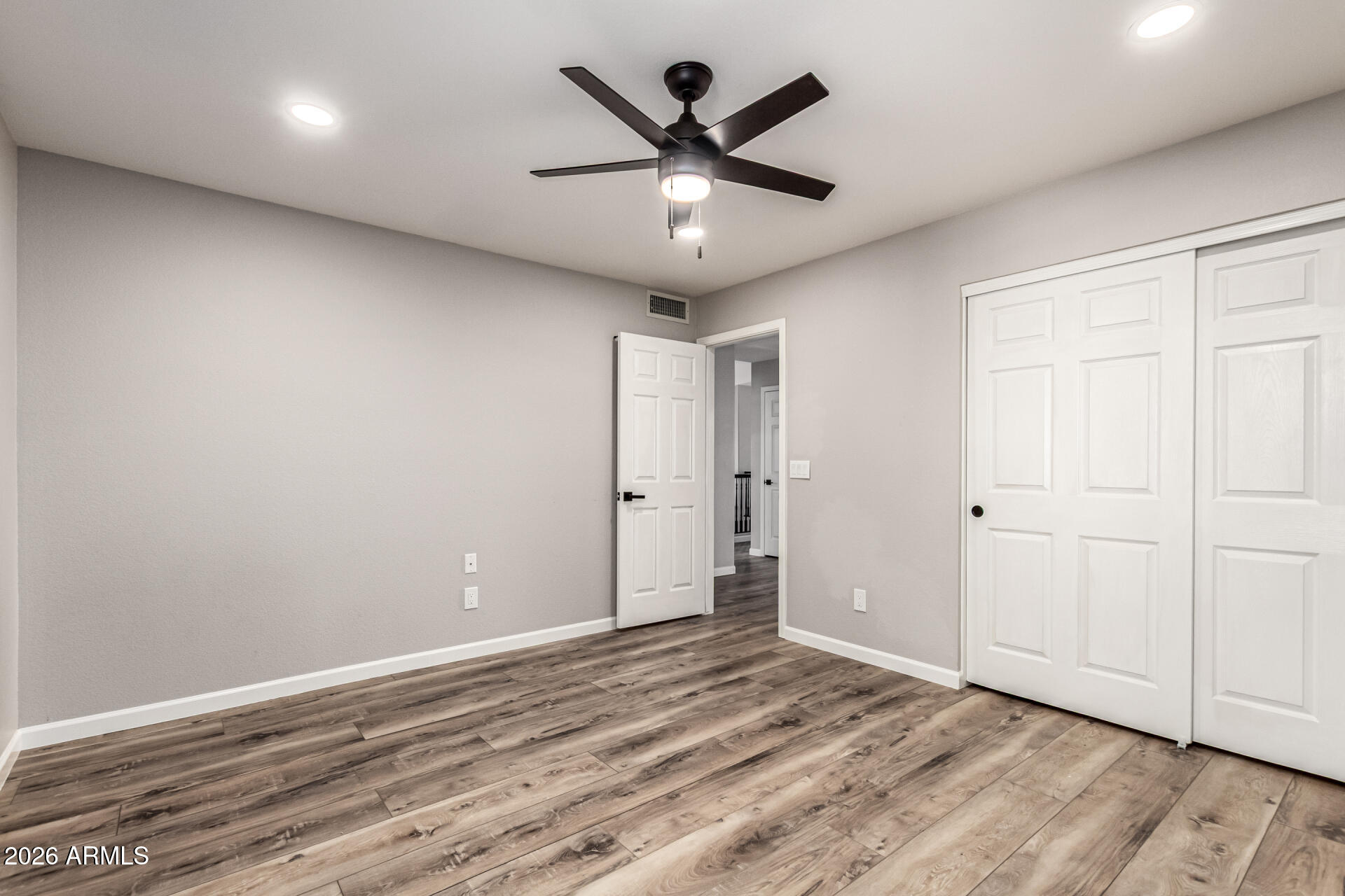 6455 East Raftriver Street Mesa, AZ 85215 - Photo 27 of 36 an empty room with wooden floor and ceiling fan