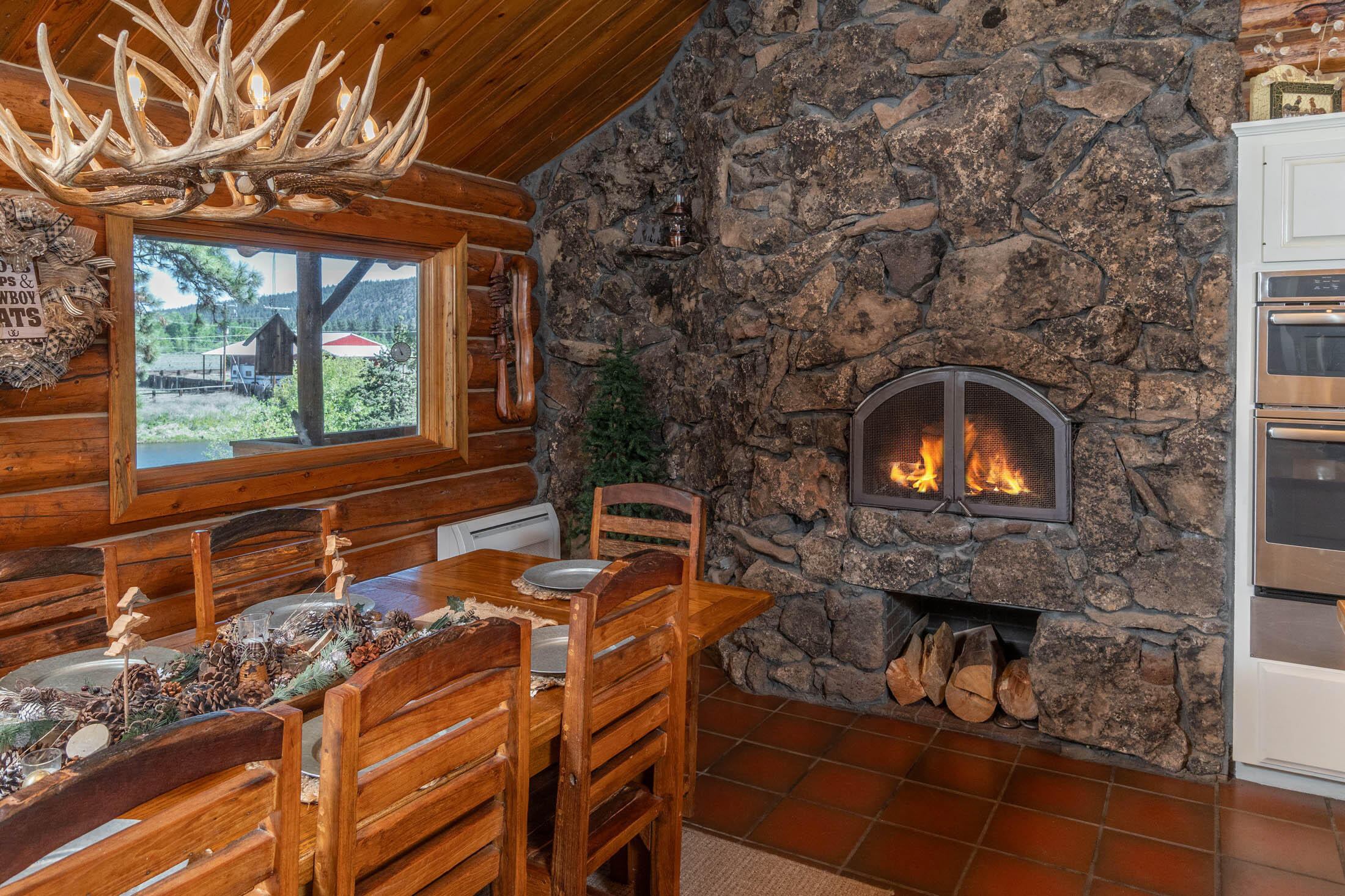 32907 River Bend Road Chiloquin, OR 97624 - Photo 5 of 83 a living room with a fireplace wooden floor and a large window