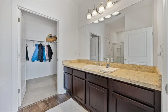 a bathroom with a granite countertop sink a light fixture and a mirror