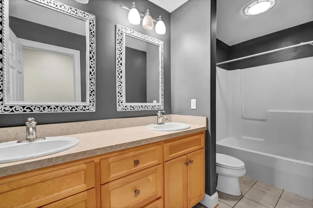 a bathroom with a granite countertop sink toilet a large mirror a bathtub and shower