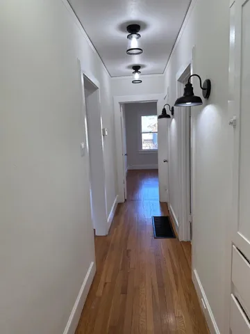 a view of a hallway with wooden floor and staircase