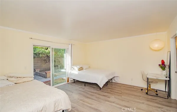a spacious bedroom with a bed and wooden floor
