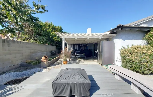 a view of a patio with table and chairs potted plants with floor to ceiling window and tree