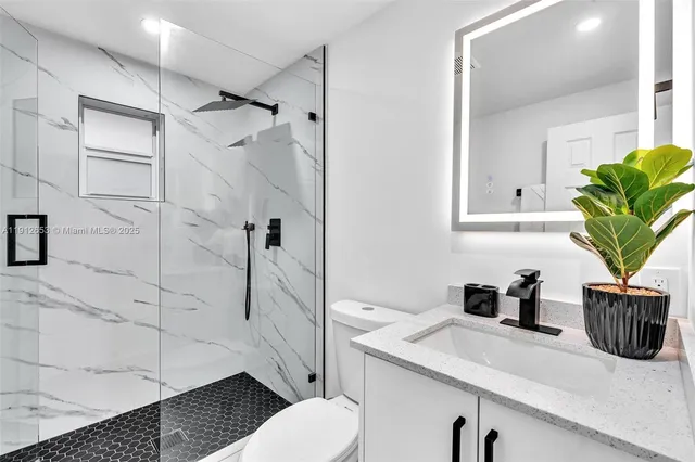 a bathroom with a sink a toilet and shower