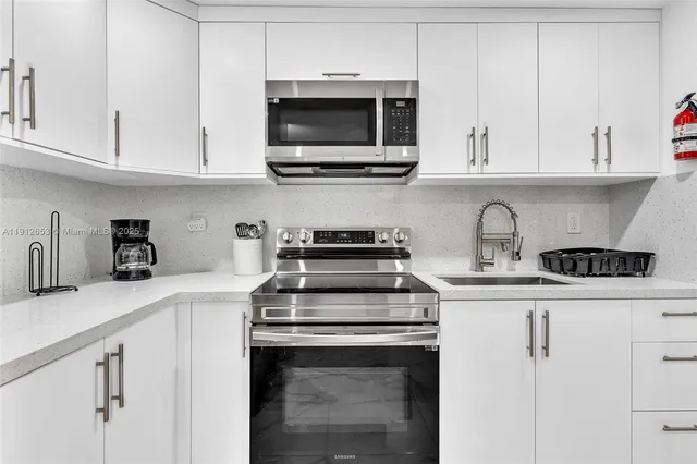 a kitchen with cabinets stainless steel appliances and a sink
