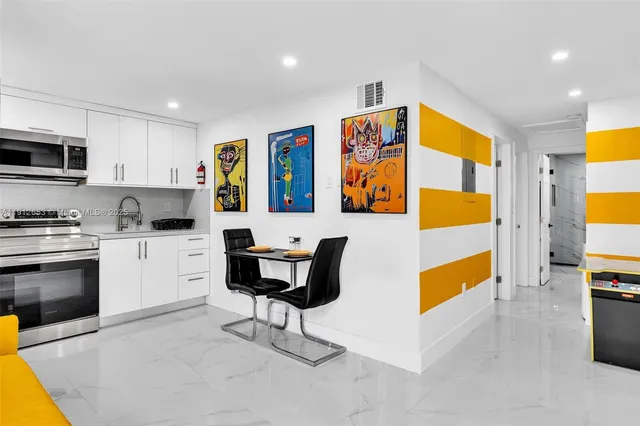 a kitchen with stainless steel appliances kitchen island granite countertop a refrigerator and a stove top oven