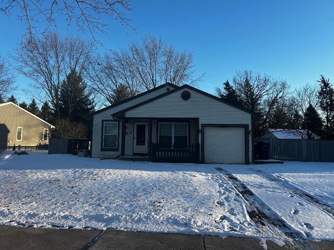 a front view of a house with a yard and trees