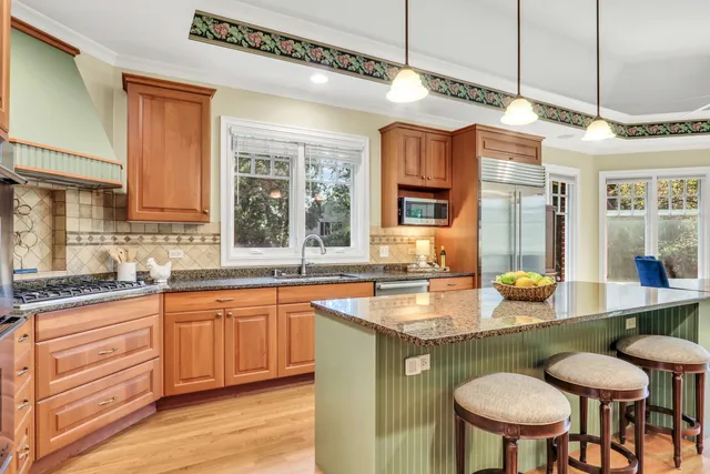 a kitchen with cabinets a sink and chairs