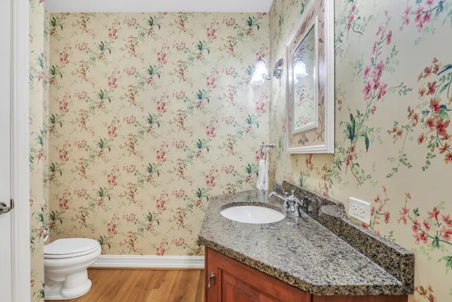 a bathroom with a granite countertop sink and a toilet