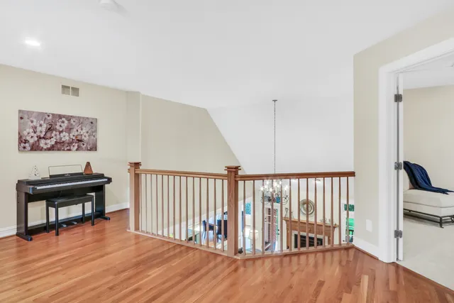 a view of a hallway with wooden floor and furniture