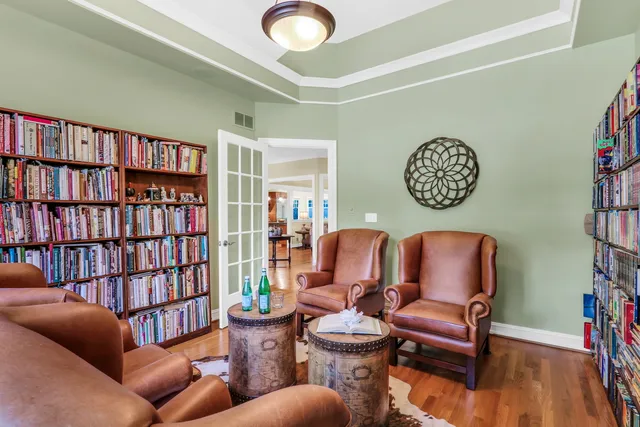 a living room with furniture a bookshelf and a window