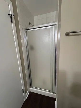 a bathroom with a glass door shower and vanity