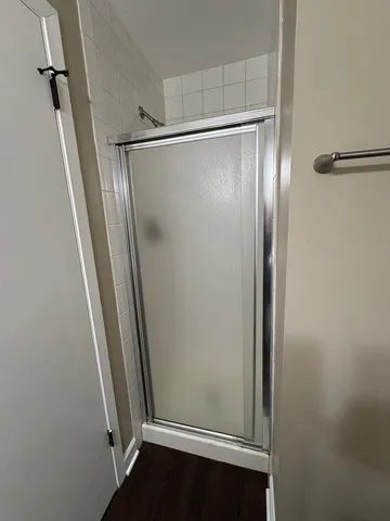 a bathroom with a glass door shower and vanity