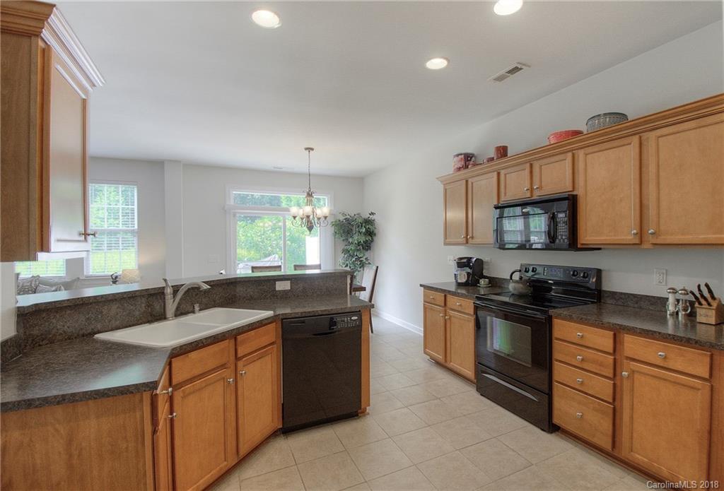 6831 Maricopa Road Charlotte, NC 28277 - Photo 13 of 23 a kitchen with stainless steel appliances granite countertop a sink stove and microwave