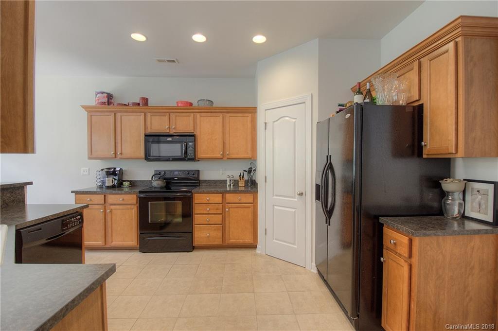 6831 Maricopa Road Charlotte, NC 28277 - Photo 14 of 23 a kitchen with granite countertop a refrigerator and a stove top oven