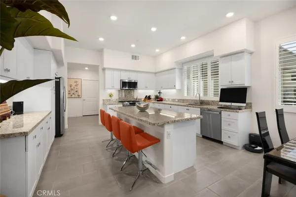 a front view of a house with a yard and potted plants
