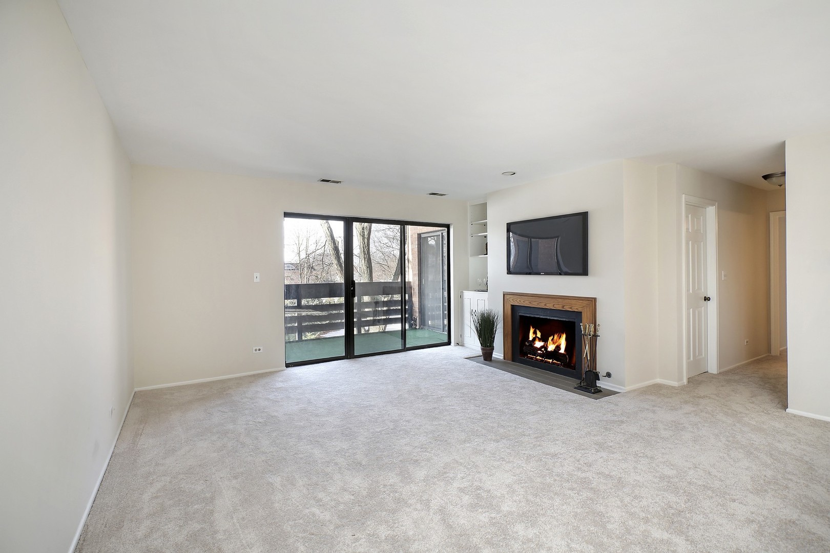 1088 Shermer Road, Unit 208 Northbrook, IL 60062 - Photo 3 of 15 a view of an empty room with a fireplace and a window