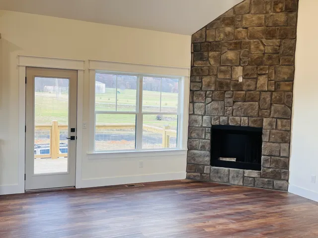 a view of a livingroom with hardwood floor and a kitchen