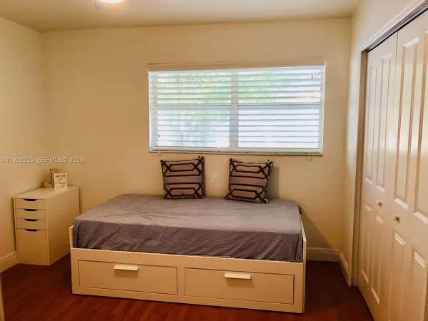 a large bed sitting in a bedroom next to a window