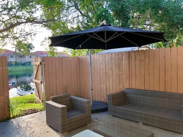 a backyard of a house with table and chairs under an umbrella