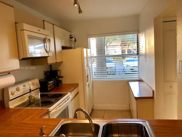 a kitchen with a sink a counter top space and stainless steel appliances