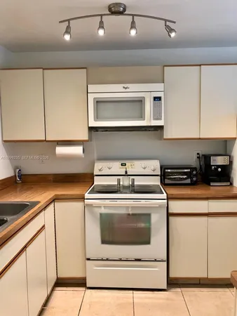 a kitchen with a stove top oven and cabinets