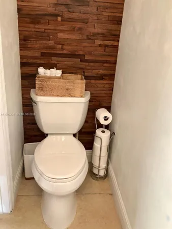 a toilet sitting next to a white wall