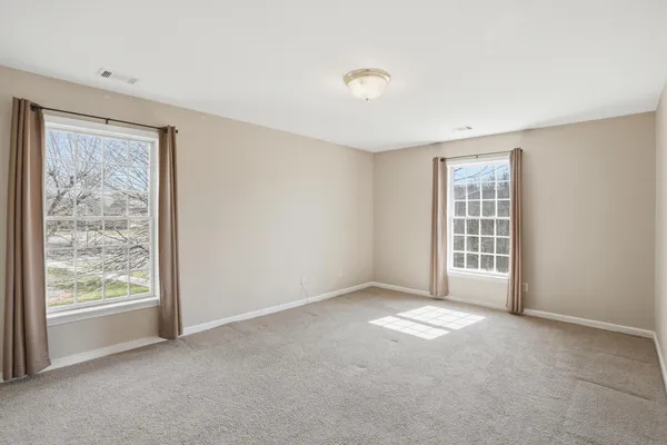 a view of a big room with windows and chandelier fan